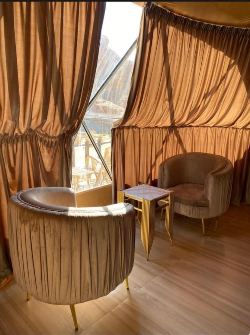 Cozy interior lounge seating with dramatic view over the red dunes