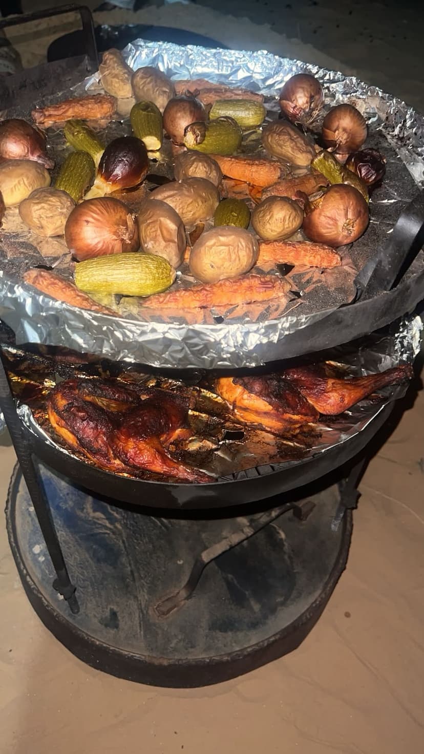 Traditional Bedouin Zarb oven lifted from underground sand pit with roasted chicken and vegetables